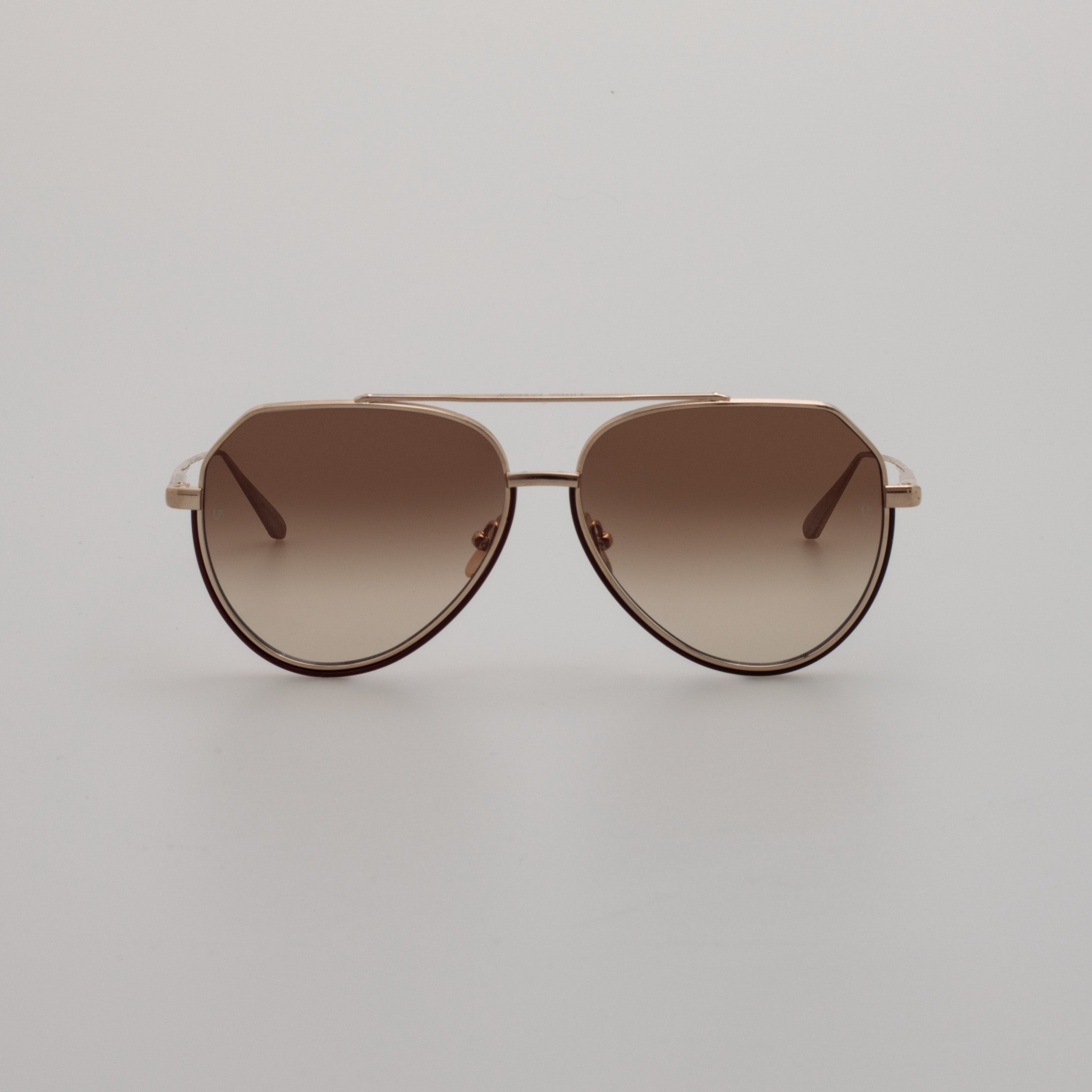 A pair of light gold aviator sunglasses with mocha gradient lenses, displayed on a neutral background.