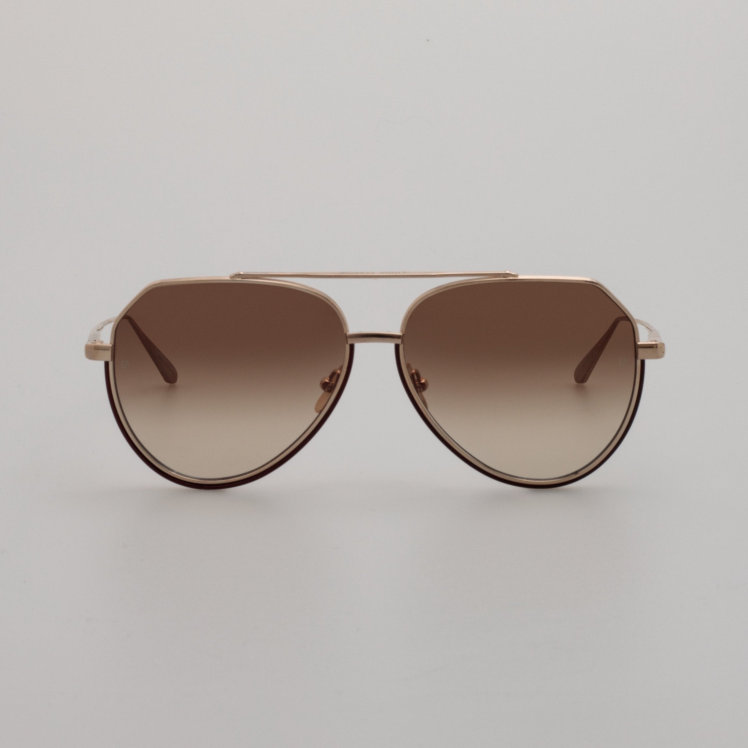 A pair of light gold aviator sunglasses with mocha gradient lenses, displayed on a neutral background.
